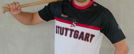 Mann präsentiert das schwarz-rot-weiße Gewinnertrikot des TVC Fantrikot Battles 2026