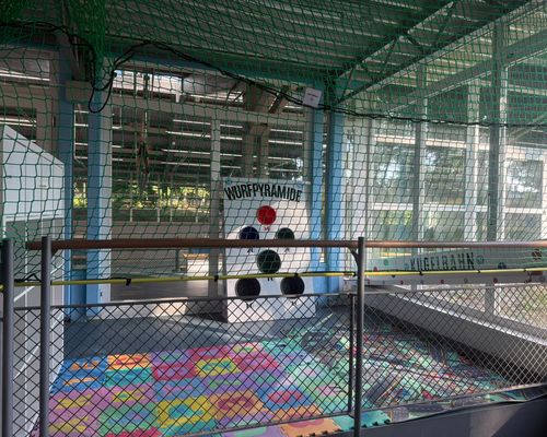 Spielzimmer in der TVC Dreifeldhalle mit bunten Spielmatten, Wurfpyramide, Kugelbahn und Sicherheitsnetz.