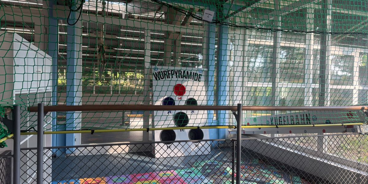 Spielzimmer in der TVC Dreifeldhalle mit bunten Spielmatten, Wurfpyramide, Kugelbahn und Sicherheitsnetz.